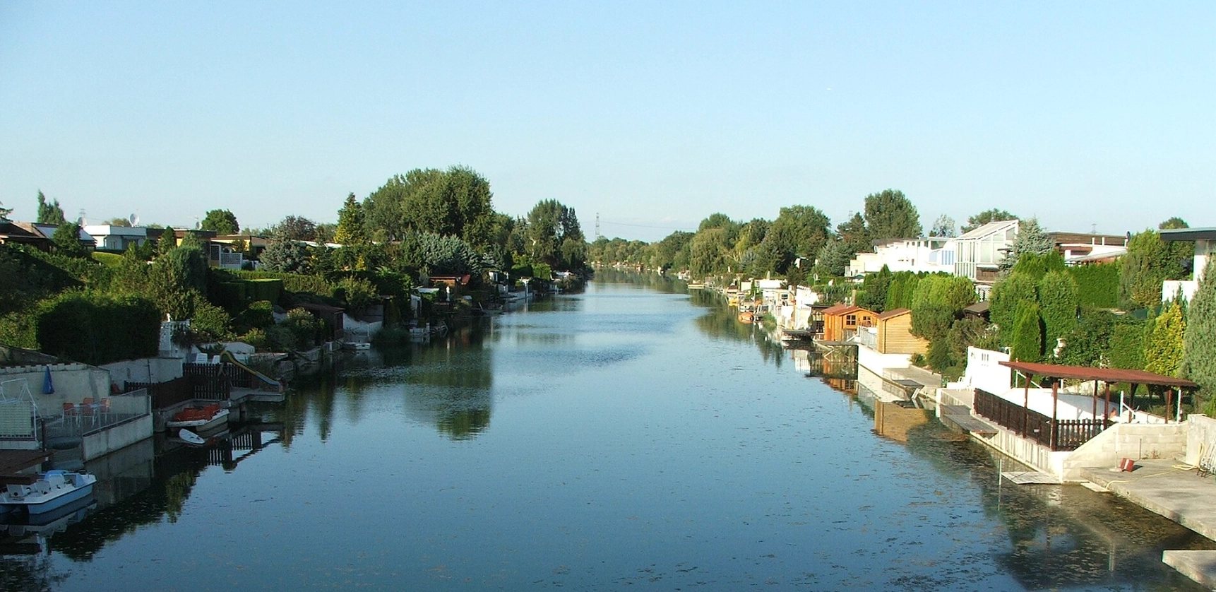 Blick auf den Donau-Oder-Kanal mit Häusern und Gärten am Ufer